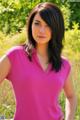 A woman in a pink shirt posing for a picture.