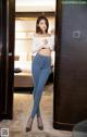 A woman standing in front of a door in a hotel room.