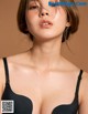A woman wearing a black bra with the words "Nude for you"