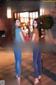 A couple of women standing next to each other on a sidewalk.