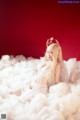 A woman in a white lingerie sitting on a cloud.