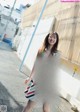 A woman in a colorful dress is walking down the street.