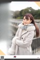 A woman in a white coat is posing for a picture.