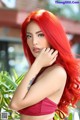 A woman with long red hair posing for a picture.