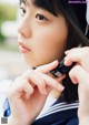 A woman in a sailor outfit talking on a cell phone.